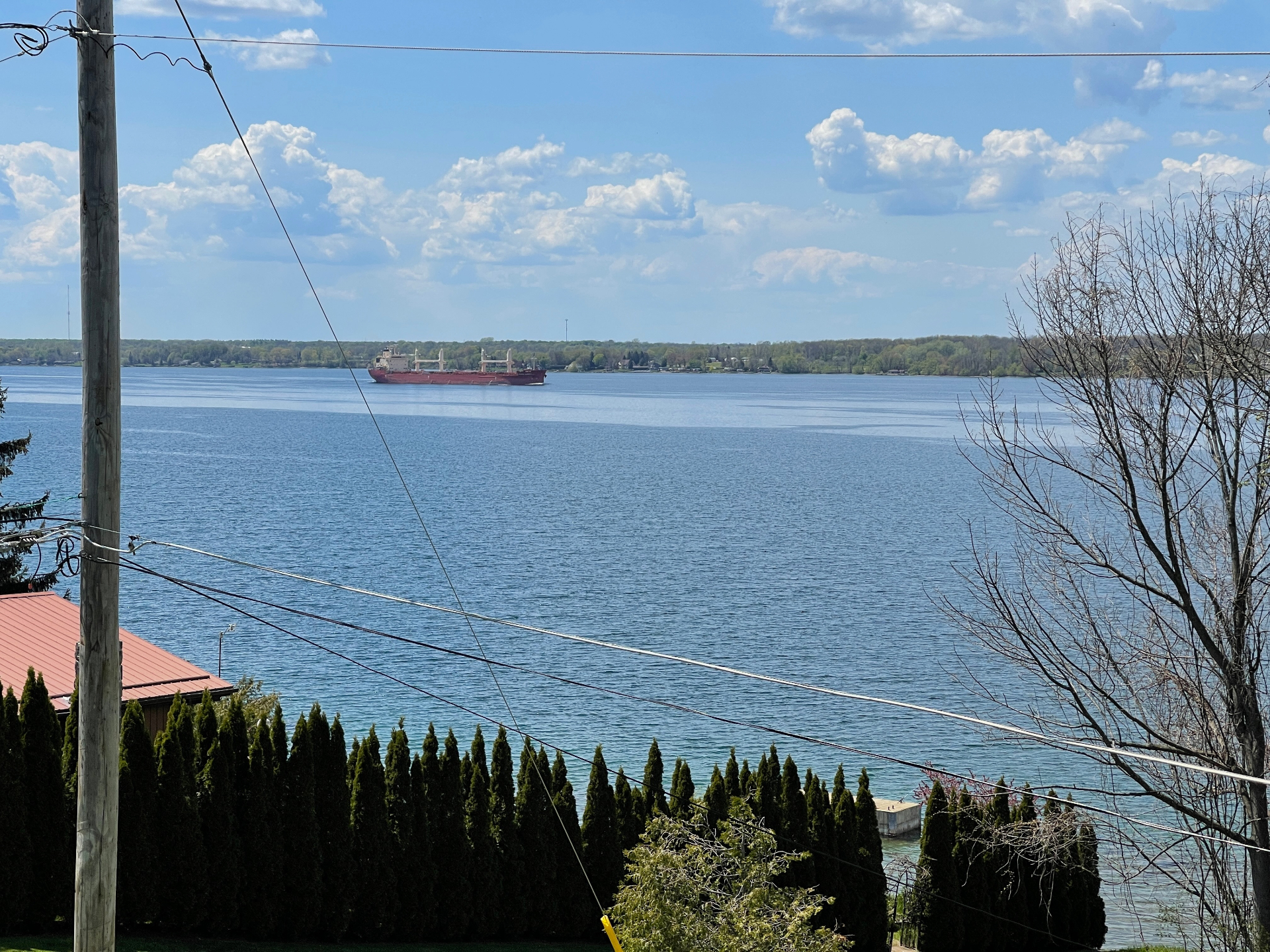 A freighter cruising past the shoreline on a clear blue day